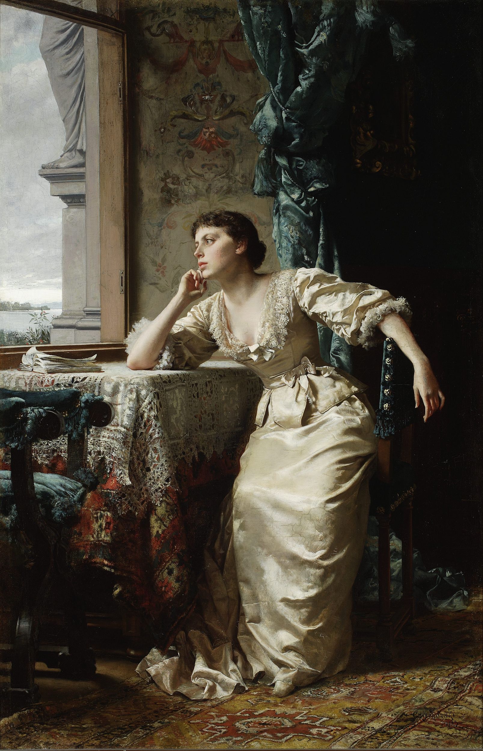 A woman with her fingers on her chin sitting at a table while looking out the window