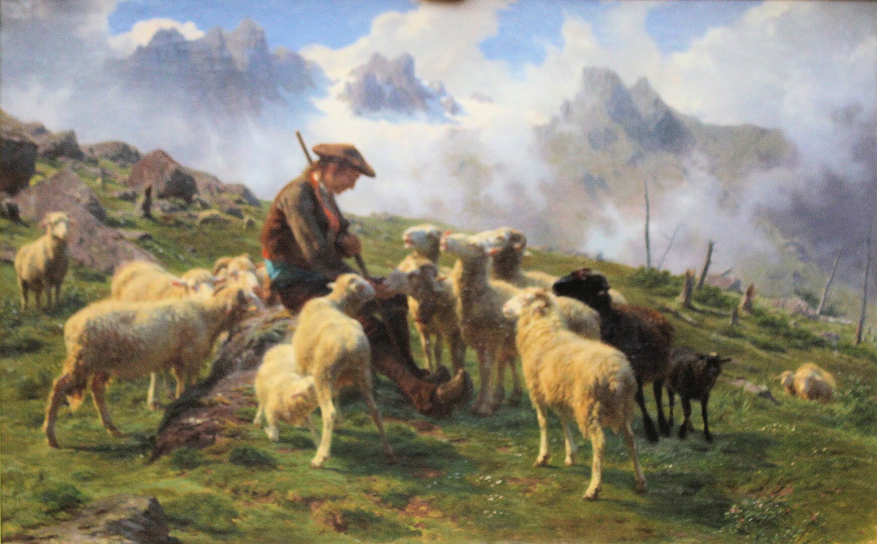 A woman is surrounded by a group of sheep as she rests, sitting on a grassy hillside.