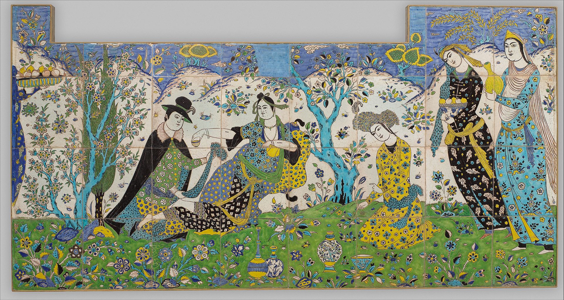 Ceramic tiles depicting a garden scene in a forest in which a woman leans on a pillow while a man kneels before her. Other figures offer refreshments.
