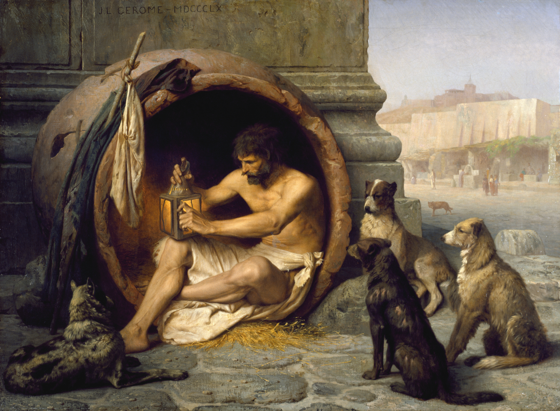 A man sits in an enclosed circular structure with a few dogs surrounding him.