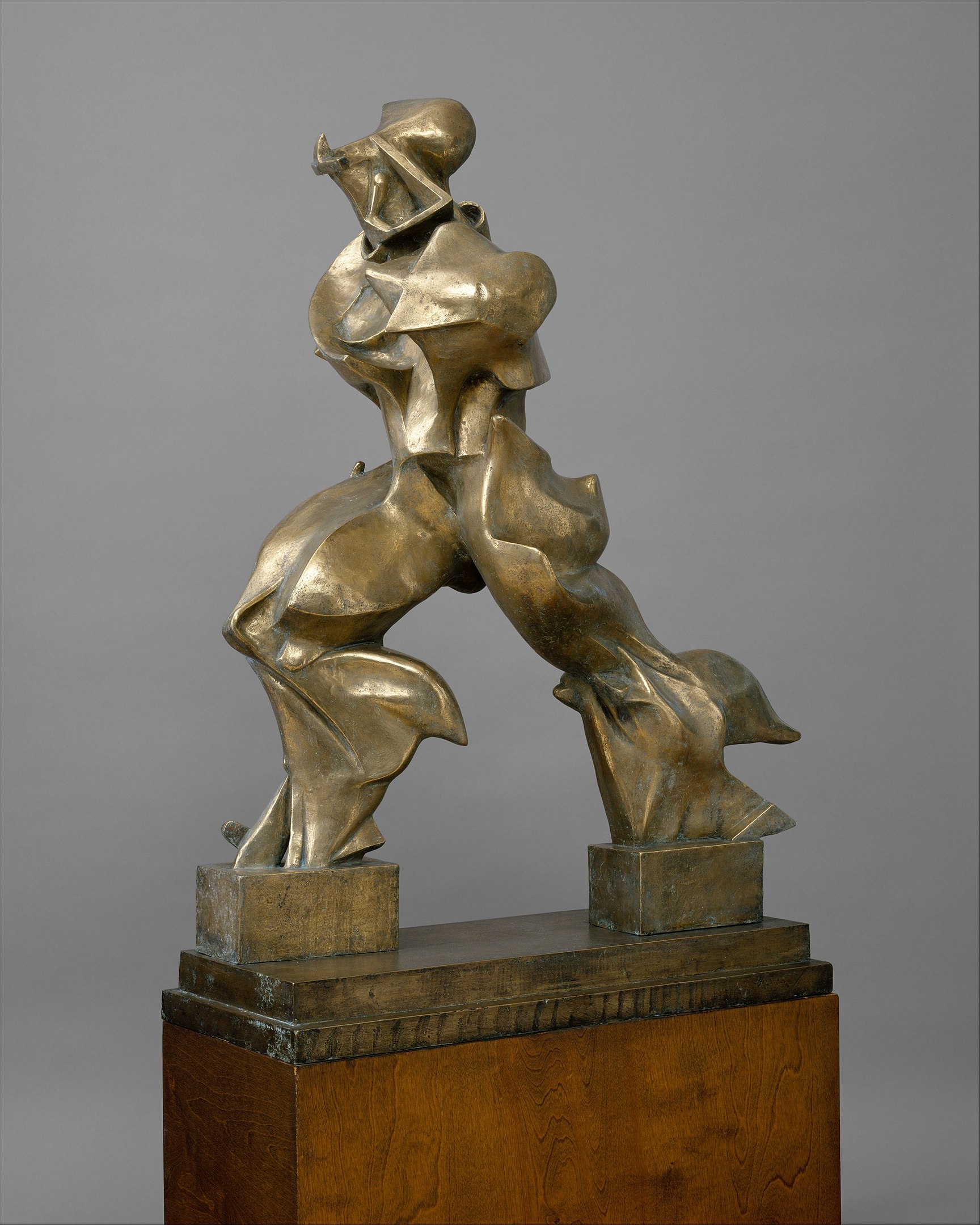 An abstract sculpture of a human figure striding