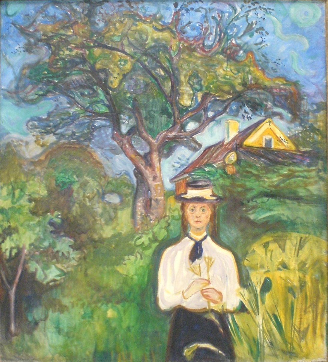 A girl standing in front of an apple tree with a house visible in the background