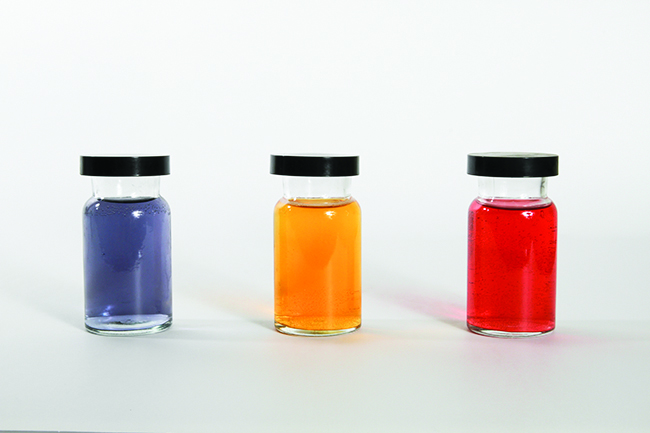 This figure shows three containers filled with liquids of different colors. The first appears to be purple, the second, orange, and the third red.